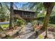 Elevated home with screened porch, lush landscaping, and a gravel pathway at 1205 Sutton Trl, Geneva, FL 32732