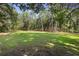 Large backyard with lush green grass and tall trees at 1205 Sutton Trl, Geneva, FL 32732