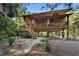 Rustic two-story home on stilts with a wooden exterior and large deck at 1205 Sutton Trl, Geneva, FL 32732
