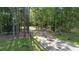 Long driveway leading to a house through a lush, wooded landscape at 1205 Sutton Trl, Geneva, FL 32732