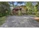 Rustic two-story home on stilts with a wooden exterior and large deck at 1205 Sutton Trl, Geneva, FL 32732