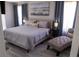 Main bedroom with king-size bed, neutral color palette, and a chaise lounge at 1002 Calabria Ave, Davenport, FL 33897