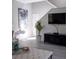 Bright living room featuring hardwood floors, stylish furniture, and a large TV at 1002 Calabria Ave, Davenport, FL 33897