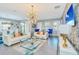 Bright living room with white sofas, blue armchairs, and a large chandelier at 1870 Sawyer Palm Pl, Kissimmee, FL 34747