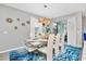 Elegant dining room with a modern table, white chairs, and a blue rug at 1870 Sawyer Palm Pl, Kissimmee, FL 34747