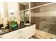 Bathroom with double vanity, granite countertop, and a walk-in shower at 17401 Serenidad Blvd, Clermont, FL 34714