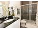 Modern bathroom with a walk-in shower and granite vanity at 17401 Serenidad Blvd, Clermont, FL 34714