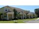 Row of townhomes with yellow exteriors, landscaping, and parking at 17401 Serenidad Blvd, Clermont, FL 34714
