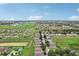 Aerial view of a residential neighborhood with houses, green spaces, and a community pool at 475 Windsor Pl, Davenport, FL 33896