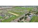 Aerial view of a residential community with houses, a pool, and green areas at 475 Windsor Pl, Davenport, FL 33896