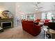 Open living space featuring a red sofa, fireplace, and views into the kitchen area at 318 Stone Castle Loop, Lady Lake, FL 32159