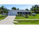 One-story home with a gray exterior, two-car garage, and nicely landscaped yard at 318 Stone Castle Loop, Lady Lake, FL 32159