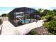 Landscaped backyard with a screened pool and patio area at 318 Stone Castle Loop, Lady Lake, FL 32159
