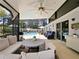 Covered lanai with seating, ceiling fan, and pool view at 318 Stone Castle Loop, Lady Lake, FL 32159