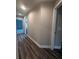 Hallway leading to garage and other rooms with wood-look flooring at 12202 Se 87Th Ct, Belleview, FL 34420