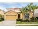 Two story house with a two car garage and landscaping at 6047 Broad Oak Dr, Davenport, FL 33837