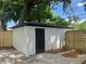 White storage shed with black door in backyard at 1639 Silver Star Rd, Orlando, FL 32804