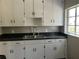 Kitchen with white cabinets, granite counters, and black appliances at 1639 Silver Star Rd, Orlando, FL 32804