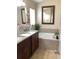 Elegant bathroom with double sinks, granite countertop, and a soaking tub at 514 Tree Shore Dr, Orlando, FL 32825