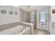 Bathroom with soaking tub, walk-in shower, and exterior access at 8810 Macapa Dr, Kissimmee, FL 34747