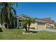 Tan one-story house with gray roof, two-car garage, and landscaped yard at 2635 Quarterdeck Ct, Kissimmee, FL 34743