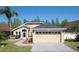 Tan one-story house with gray roof, two-car garage, and landscaped yard at 2635 Quarterdeck Ct, Kissimmee, FL 34743