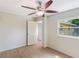 Bright bedroom with wood-look floors, ceiling fan, and access to another room at 6809 Ambassador Dr, Orlando, FL 32818