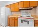 Kitchen with white appliances and wood cabinets at 1404 E Alfred St, Tavares, FL 32778