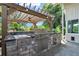 Stainless steel outdoor kitchen with granite countertops, pergola, and built-in grill at 2881 St George Dr, Davenport, FL 33837
