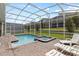 Screened pool and spa with lounge chairs at 1158 Drop Ln, Davenport, FL 33896