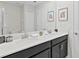 Bathroom with double sinks, dark vanity, and a mirror at 1158 Drop Ln, Davenport, FL 33896