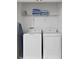 Laundry closet with washer, dryer, and shelving at 1158 Drop Ln, Davenport, FL 33896