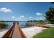 Wooden dock extending to lake with sandy beach at 17335 Chateau Pine Way, Clermont, FL 34711