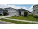House exterior with gray siding, two-car garage, and solar panels at 462 Hamlet Loop, Davenport, FL 33837