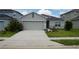 House exterior with gray siding, two-car garage, and solar panels at 462 Hamlet Loop, Davenport, FL 33837