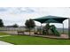 Community playground with shaded play structures, swings, and benches at 462 Hamlet Loop, Davenport, FL 33837