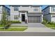Two-story home with gray exterior, black garage door, and landscaping at 5936 High Seas Dr, Orlando, FL 32821