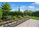 Landscaped backyard with stone retaining wall, herbs, and paver patio at 4909 W Fountainwood Dr, St Cloud, FL 34772