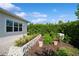 Landscaped backyard with stone retaining wall, herbs, and paver patio at 4909 W Fountainwood Dr, St Cloud, FL 34772