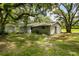 Ranch-style home with mature landscaping and a detached shed at 1406 S Hoagland Blvd, Kissimmee, FL 34746
