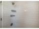 White tiled shower with two wire shelves for toiletries at 1406 S Hoagland Blvd, Kissimmee, FL 34746