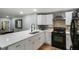Modern kitchen with white cabinets, quartz countertops, and black appliances at 1406 S Hoagland Blvd, Kissimmee, FL 34746
