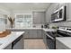 Modern kitchen with gray cabinets, white countertops, and stainless steel appliances at 1676 Tropical Palms Cir, Kissimmee, FL 34747
