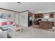 Open living room with a view of the kitchen, featuring neutral carpeting and a sofa at 18955 Se 107Th Pl, Ocklawaha, FL 32179