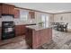 Spacious kitchen with dark wooden cabinets, granite countertops, and island at 18955 Se 107Th Pl, Ocklawaha, FL 32179
