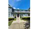 Two-story townhome with a red door and a neatly landscaped front yard at 2606 Lodi Cir # 105, Kissimmee, FL 34746