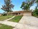 Brick ranch house with a paved driveway and landscaped yard at 509 Savona Ct, Altamonte Springs, FL 32701