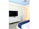 Bedroom with large TV, dresser, and access to another room at 1864 Caribbean View Ter, Kissimmee, FL 34747