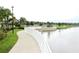 Concrete path with white fence and lake view at 1864 Caribbean View Ter, Kissimmee, FL 34747