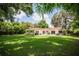 Spacious backyard with lush lawn, mature trees, and a hot tub at 11130 Park Ave, Windermere, FL 34786